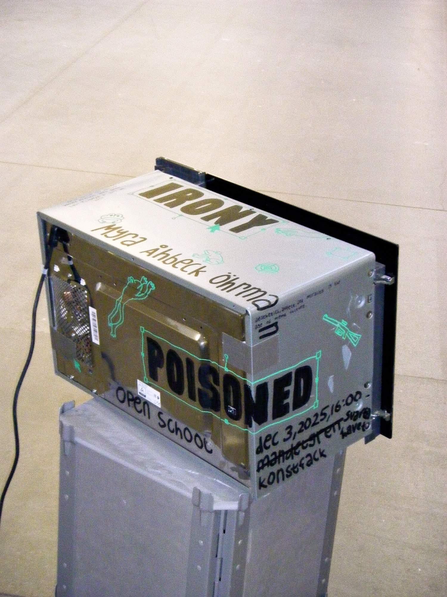 a microwave that got repurposed as a poster for myra åhbeck öhrman's lecture "irony poisoned". green frogs, graphic computer interfaces and guns are spread throughout the print.